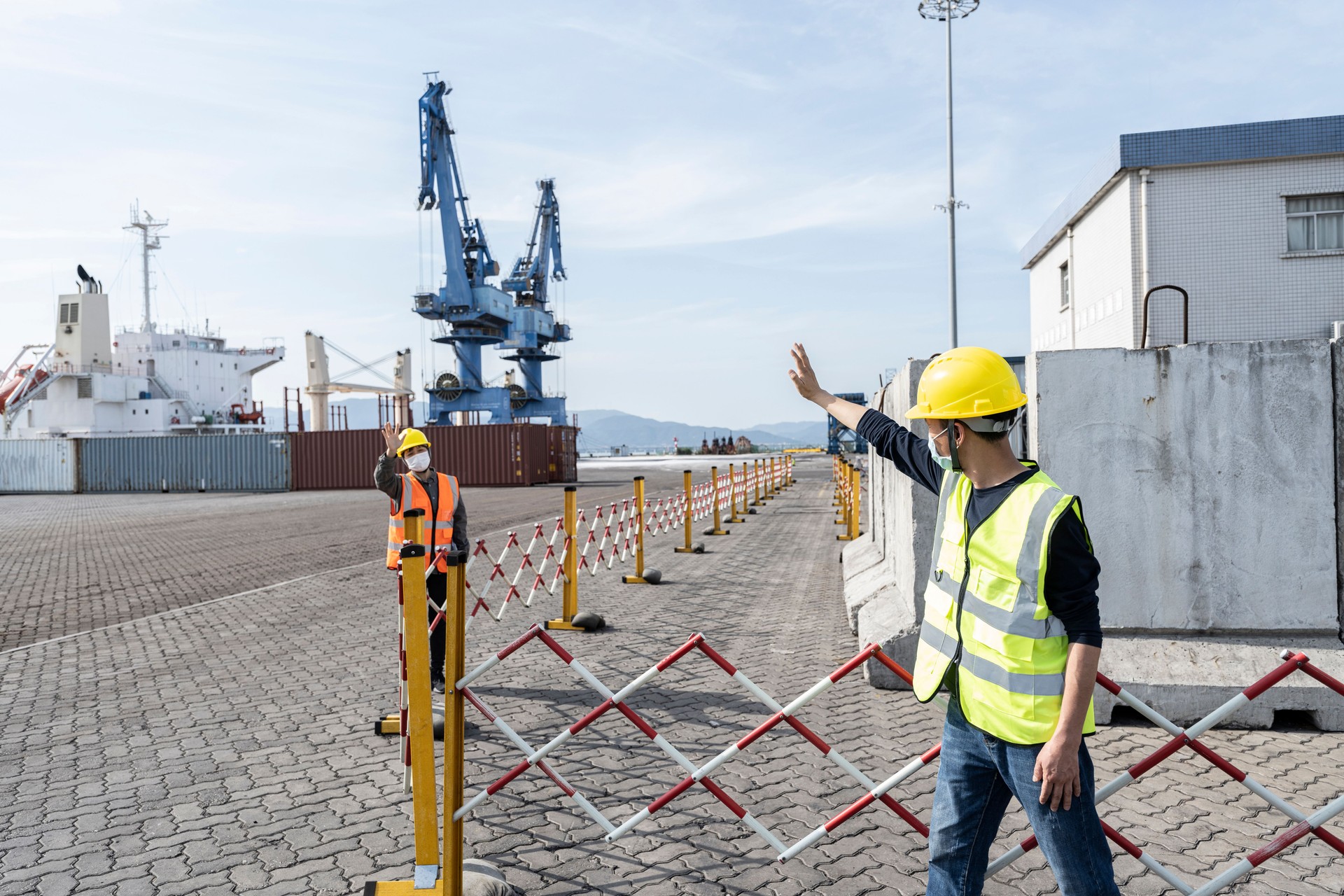 Two port engineers greet each other at a commercial freight terminal.